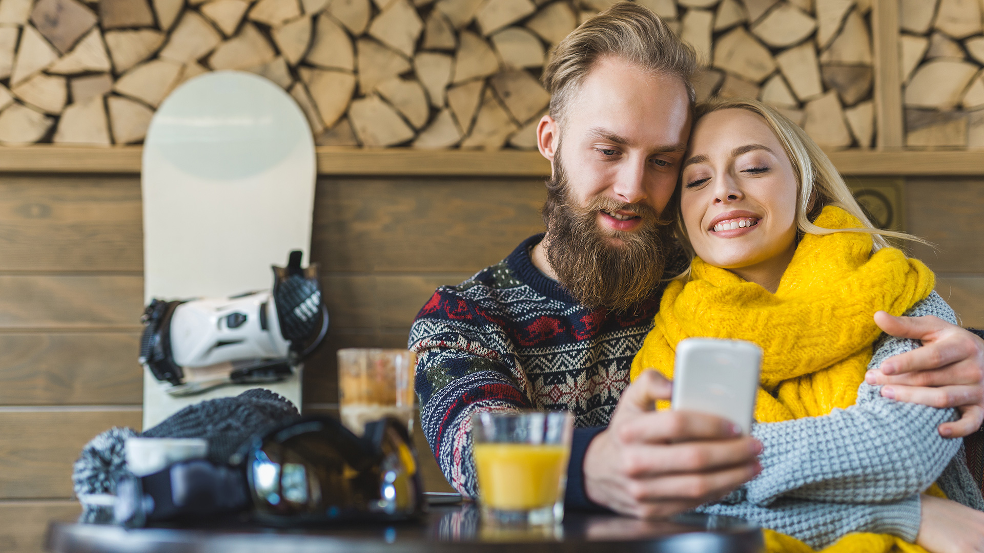 Paar in der Skihütte mit Handy